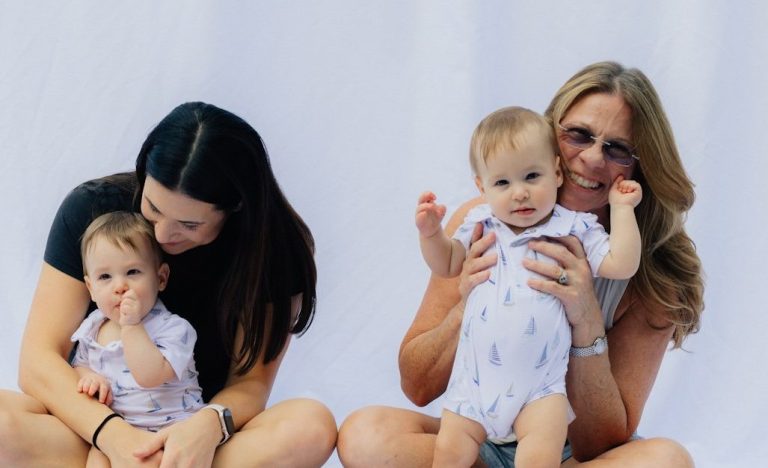 Mütter mit Kindern Zwei Frauen sitzen mit zwei Babys in einem hellen, neutralen Hintergrund.